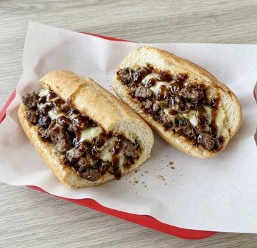 Steak & Cheese Sub with seasoned steak, melted cheese and smoky BBQ sauce, cut in half